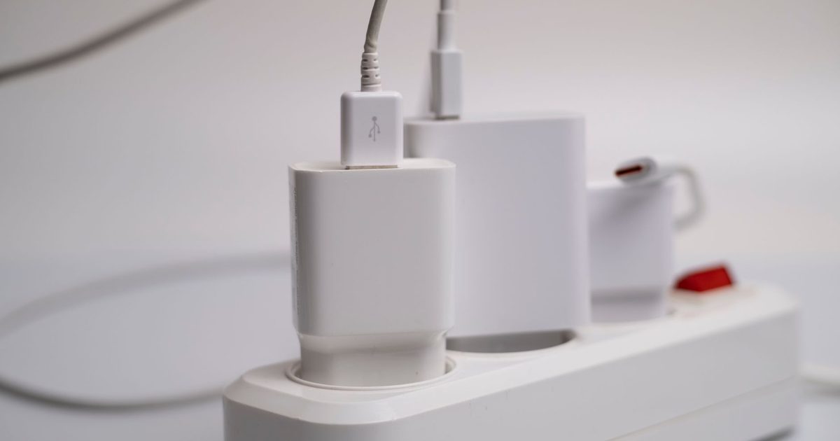 Three white USB-C charger blocks plugged into a power strip