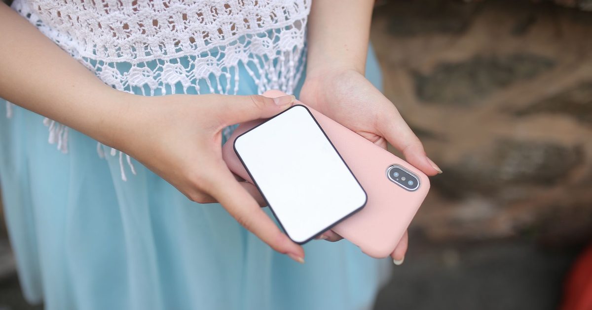 Slim white battery pack held against the back of a pink phone