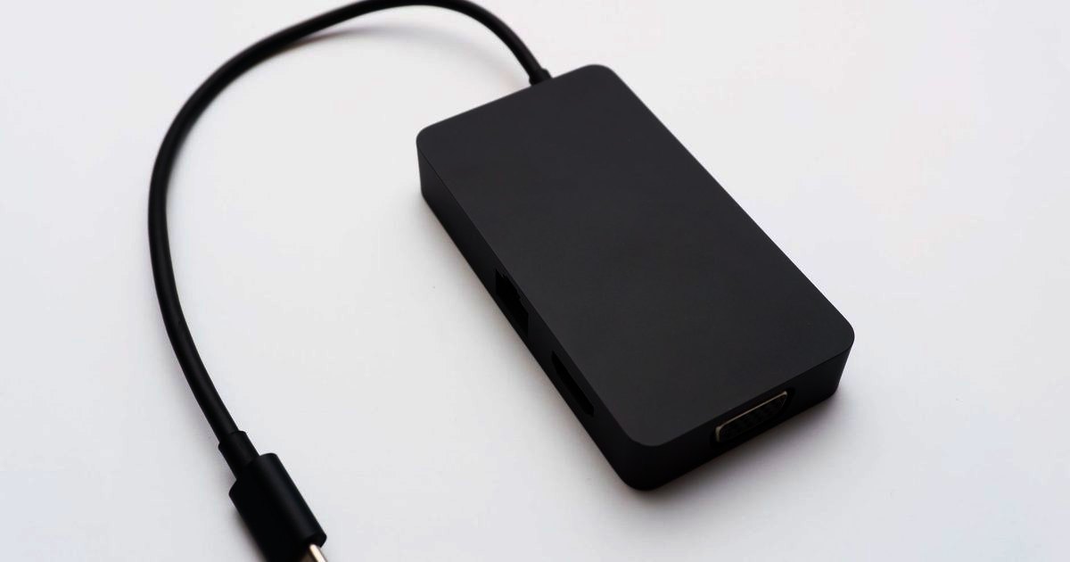 A black USB-C dongle with a single ethernet port on white