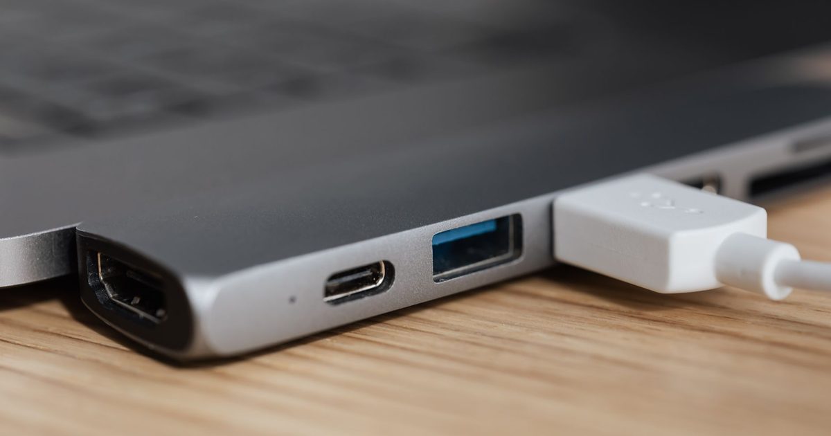 USB-C hub clipped to a laptop with HDMI, USB-C and USB-A ports visible