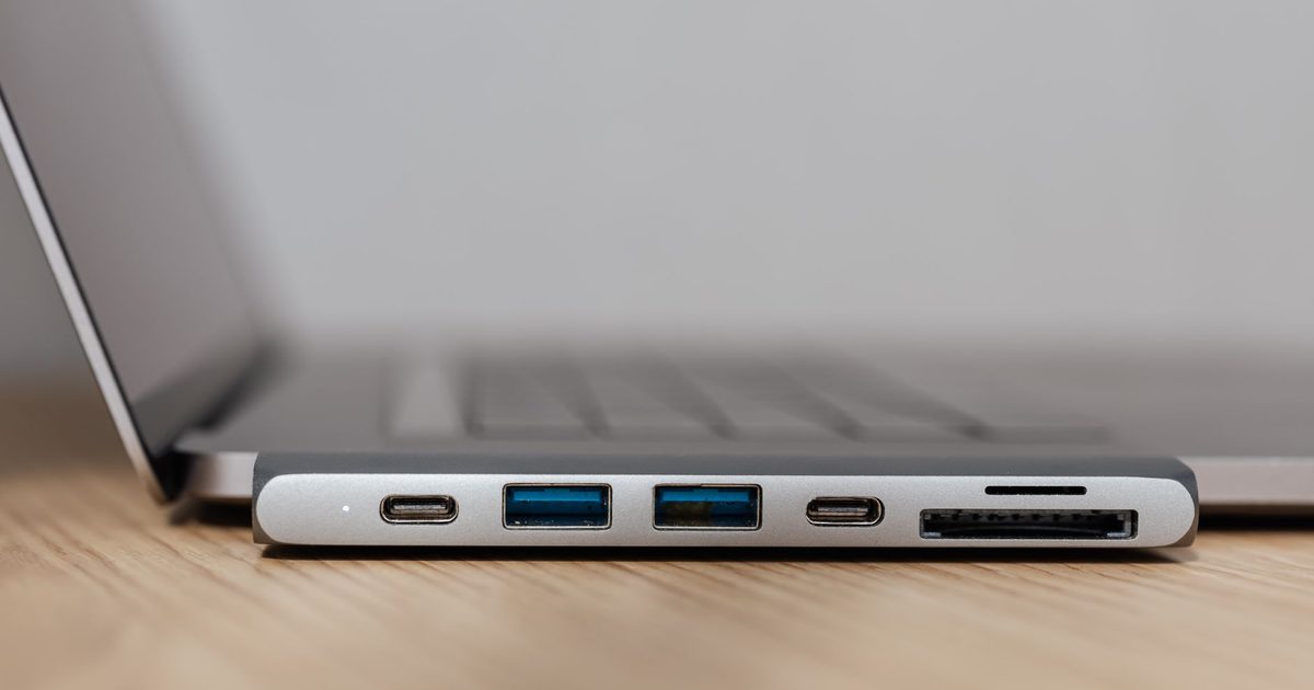 A USB-C hub clipped to a laptop with its ports facing out