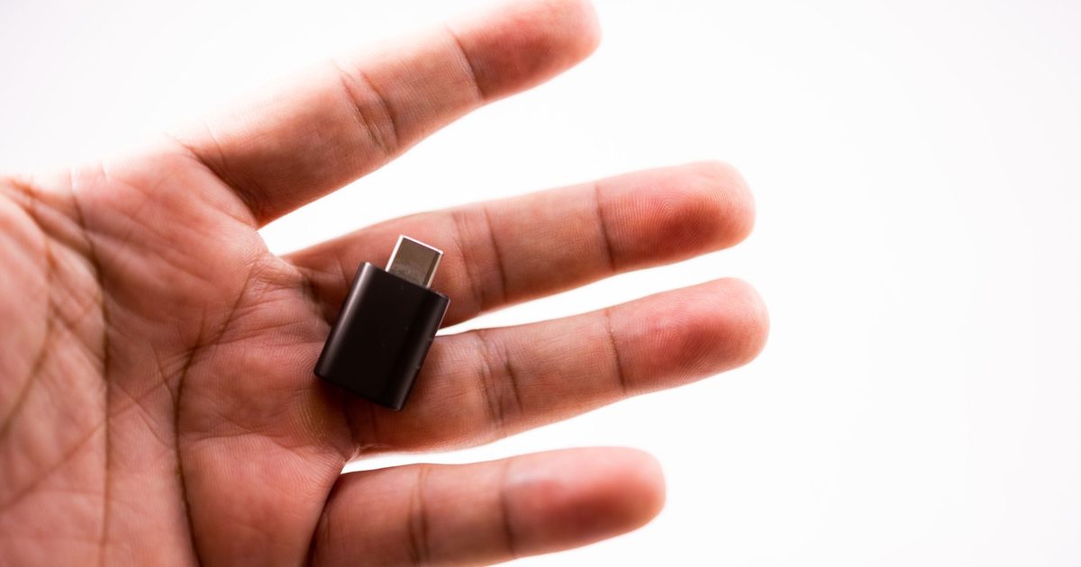 Small black USB-C adapter resting in an open palm