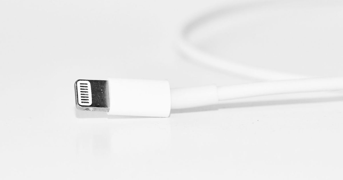 a white charging cable with a metal connector on a bright surface