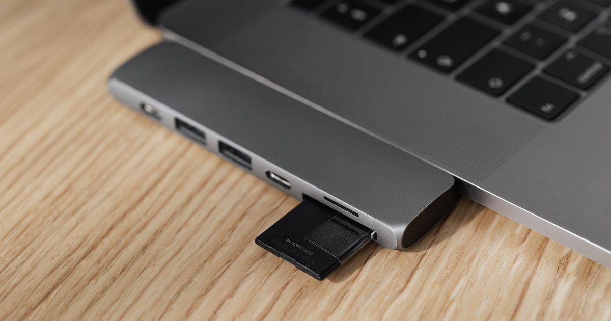 a usb-c card reader on a laptop's side port holding an sd card