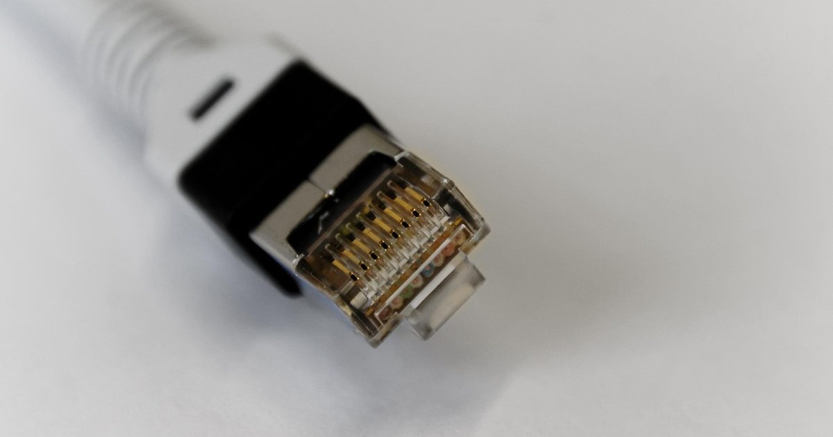 a shielded ethernet cable connector with gold contacts on a white background