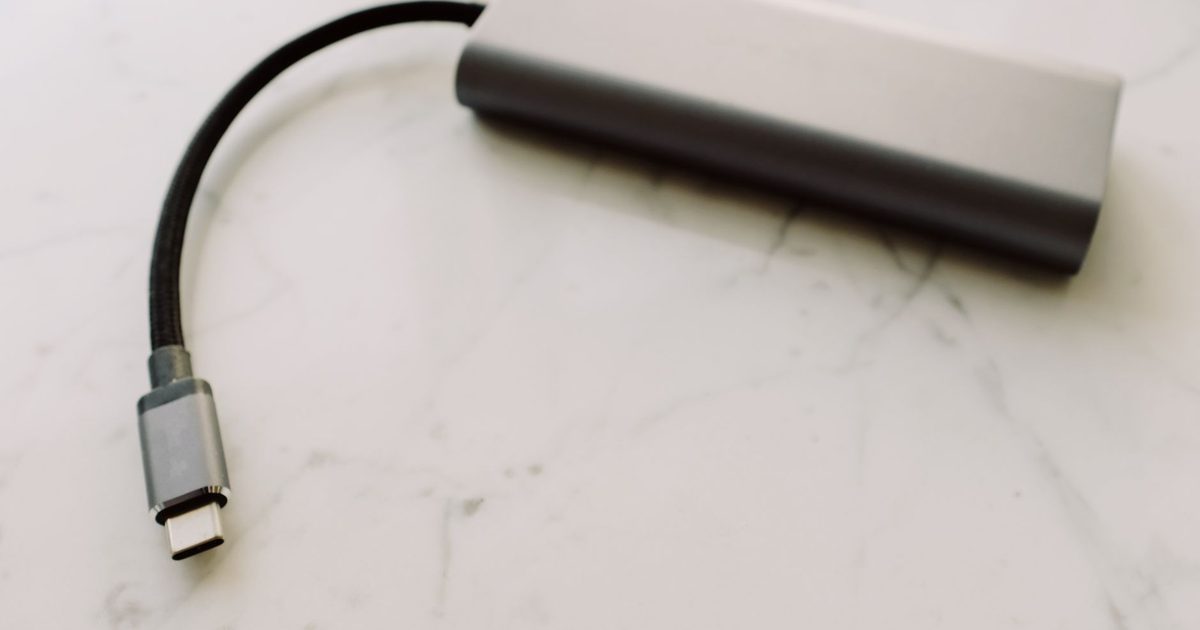 a usb-c adapter dongle with a short braided cable on a pale marble surface